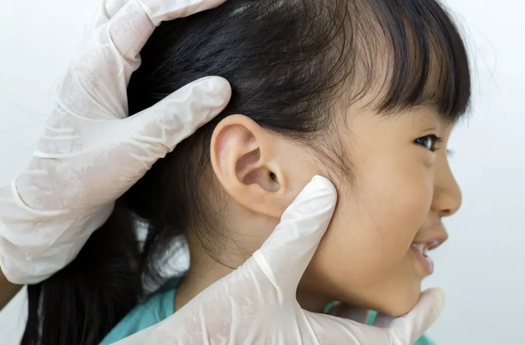 Ear specialist assessing a girl's ear during consultation