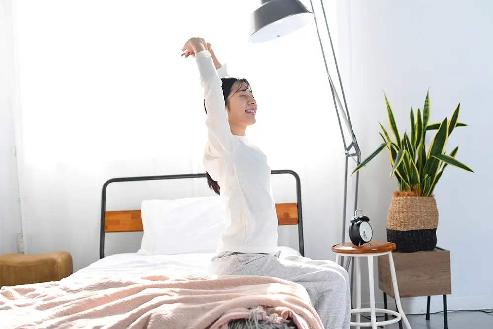 Woman waking up happy without sleep apnoea.