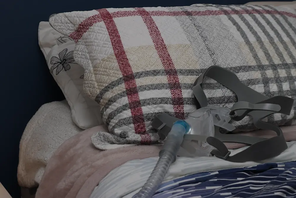 A CPAP mask used for sleep apnoea treatment placed on a bed