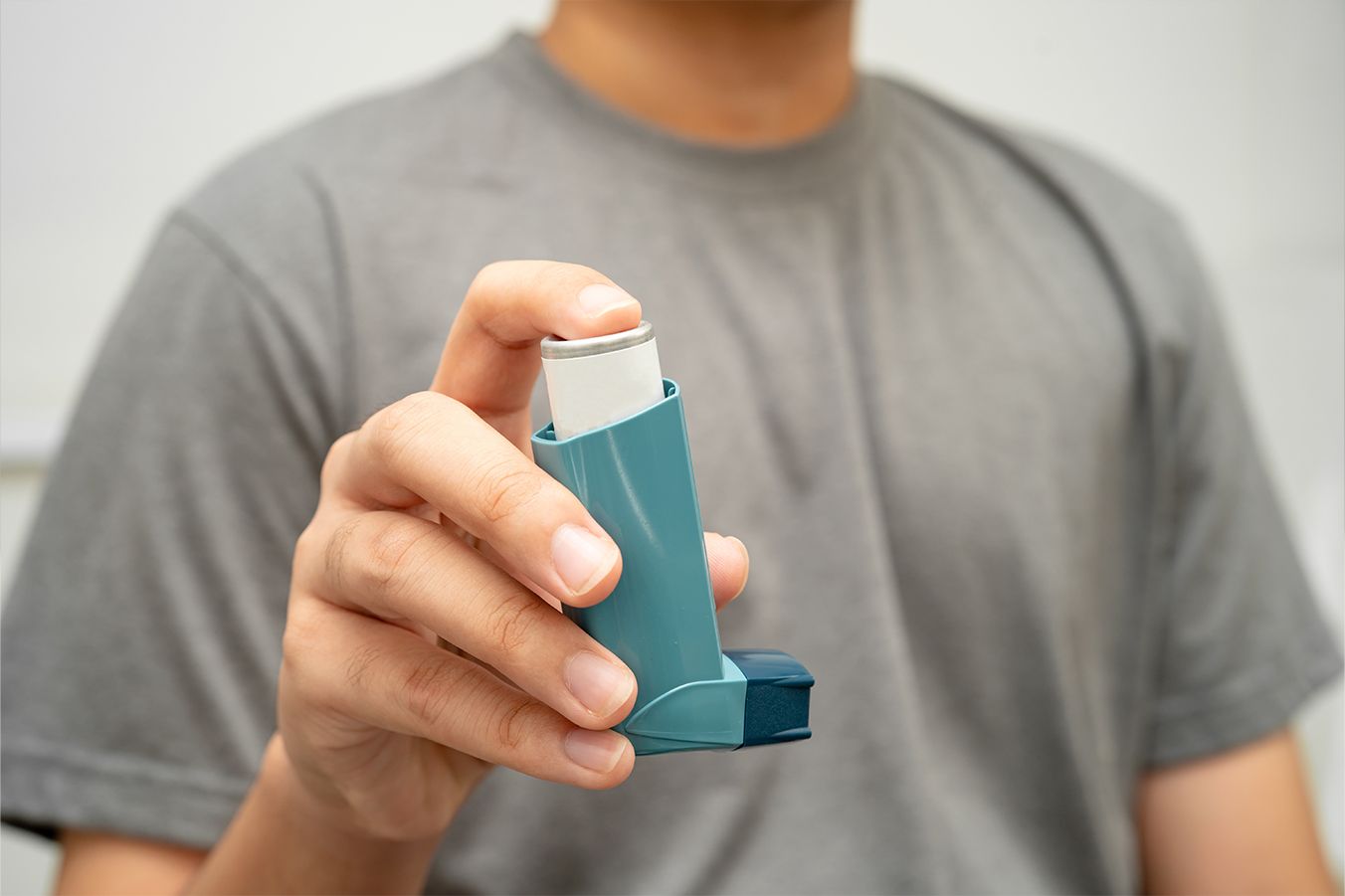 A man holding an asthma inhaler.