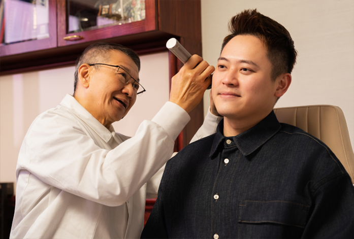 Dr Lau Chee Chong checking ear of patient